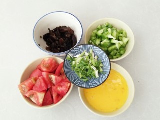 4、酸甜剪刀面,黑木耳泡发清洗干净，青椒切丁，番茄切块，香葱切碎，山鸡蛋中加入2汤匙清水打散。