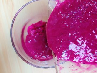 7、梦幻火龙果酸奶杯,将火龙果泥倒入杯中，盖在火龙果丁上。