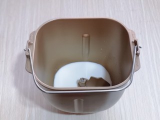 2、不一样的面食~圣诞老人馒头,将牛奶加入面包桶,再加入白砂糖。