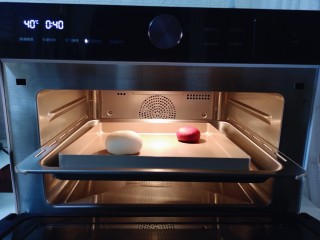 5、不一样的面食~圣诞老人馒头,把和好的面团从面包机里取出后揉圆,把两块面团放入美的蒸烤箱进行发酵。(将蒸烤箱水盒取出,加满纯净水,再将水盒放入机体推回原位)