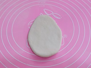 9、不一样的面食~圣诞老人馒头,开始做圣诞老人的头部、取一块白色面团揉匀擀成上窄下宽的椭圆形,放旁边备用!