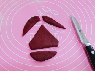 10、不一样的面食~圣诞老人馒头,开始做圣诞老人帽子、取一块红色面团揉匀擀成椭圆形薄面片、用刀把多余的部分切掉。如图!
