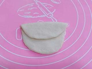14、不一样的面食~圣诞老人馒头,另取一块面团揉圆、擀成椭圆形后对折、不要对折的太齐、如图