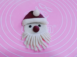 16、不一样的面食~圣诞老人馒头,把做好的胡须放在脸部的下方、整理一下胡须。圣诞老人就做好了哈!