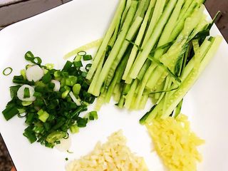3、夏日凉面,切好的黄瓜????丝、葱花、姜末、蒜末装盘备用。