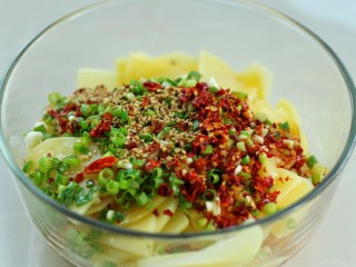 12、凉拌香辣土豆片,用筛网把热油过滤到辣椒面和芝麻上面榨出香味