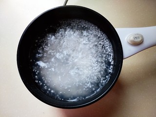 5、芒果西米捞,烧开的水倒入小西米。