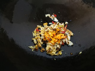 10、#咸味#蟹黄面,炒到葱白变成焦黄，出现香浓的葱油味后，再放入生姜末和辣椒圈。再放入蟹肉和蟹黄。