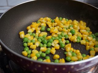 8、海鲜炒饭,用另外一个锅加入油，倒入玉米粒和豌豆