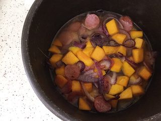 10、南瓜腊肠焖饭,炒好的食材放入电饭煲内加水，水可以少放些，不要没过食材，米饭粒粒分明会好吃些