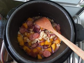 11、南瓜腊肠焖饭,加入适量生抽和盐 ，微微搅拌，盖上盖子进入焖饭模式