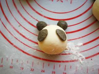 7、花样馒头-熊猫馒头,再捏2个水滴样的面片。沾水粘到熊猫的眼睛位置。