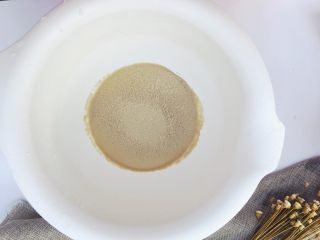 2、当主食一次可以吃三个的法棍面包,将酵母倒入装了温水的搅拌盆里，静置五分钟让酵母活化一下，直到完全溶解。