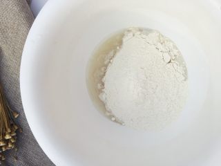 4、当主食一次可以吃三个的法棍面包,将混合均匀的粉类倒入溶解的酵母水里，倒入一半左右。