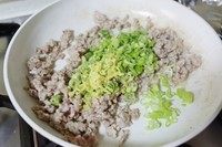 6、二合一炸酱面,肉馅煸炒变色后，加入姜末和葱青继续翻炒。