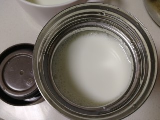 5、手工酸奶,牛奶倒入焖烧杯，用勺子舀些牛奶，滴在手背上，试试温度，感觉温热不烫就可以。
