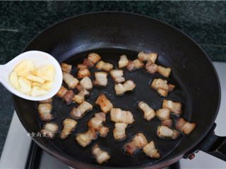 7、五花肉蒜香腊味焖饭,煸至五花肉两面焦黄色,倒入蒜头爆香