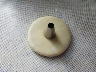 17、中式点心~玫瑰酥,取一个面胚,擀成圆形,中间用裱花嘴做一个圆形的记号。