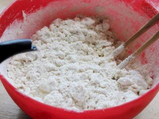 1、十味 多汁猪肉煎饺,面粉500克加入大约280克的开水，边倒边拌。