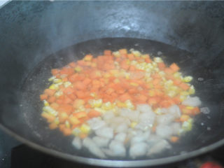5、虾仁炒饭,水烧开,将胡萝卜和玉米可以放进去汆烫至半熟后加入虾仁粒,汆烫至虾仁变色