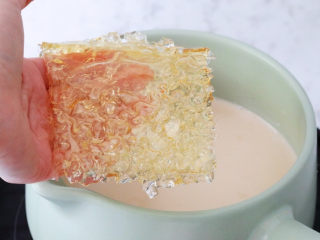 6、珍珠奶茶冻,再将茶叶捞出，吉利丁片捞出沥干水分后加入到奶茶中，继续小火加热至融化关火