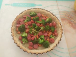 15、酸奶芝士派,把拌匀的脆皮肠和蔬菜倒入派皮里。