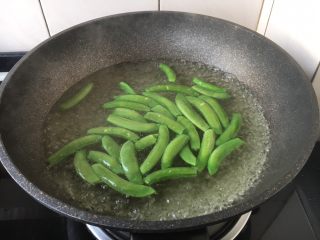 7、肉片炒黑鸡枞,锅里放入水,水开后放入少许盐盐和2滴油,放入甜豆,焯水至甜豆断生,捞出过凉水,沥干水分备用。
