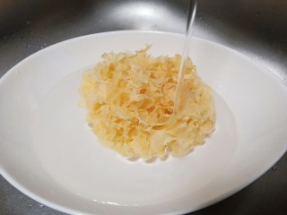 2、美容养颜的《莲子百合银耳羹》,银耳加适量的清水泡发一夜、只要一小朵就能煮出一锅软糯粘稠的银耳羹。