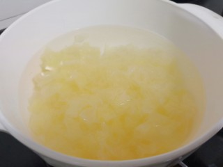 8、美容养颜的《莲子百合银耳羹》,炖锅加适量的清水、加入泡发好的白木耳、一次性加满清水。开大火烧开，中小火慢慢炖。