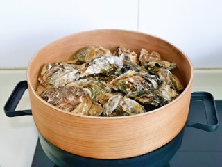 5、蒜蓉生蚝,上蒸锅,隔水蒸2-3分钟,壳裂开就可以关火。