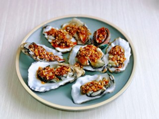 11、蒜蓉生蚝,用小勺每个贝壳里面盛一勺酱汁,也可以根据个人喜好选择。