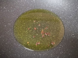 12、自制猪皮冻,炒锅内倒入适量的食用油烧热，下入花椒炝香，然后捞出炝过的花椒不要。 