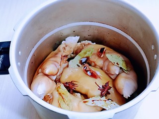 4、香辣孜然烤猪蹄,处理好的猪蹄放入高压锅中，加入酱油，讲究，八角，，桂皮，香叶，姜片。