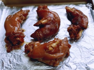 11、香辣孜然烤猪蹄,将猪蹄放在垫有锡纸的烤盘中，并间隔距离。