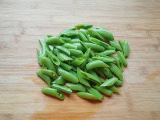 3、甜豆红萝卜炒虾仁,甜豆抽丝洗干净切成两半。