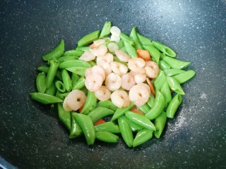11、甜豆红萝卜炒虾仁,下入虾仁一起翻炒均匀。