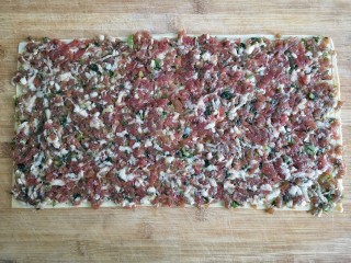 5、糖醋东北肉签子,豆腐皮铺在菜板上，将调好的肉馅均匀平铺在豆腐皮一面。