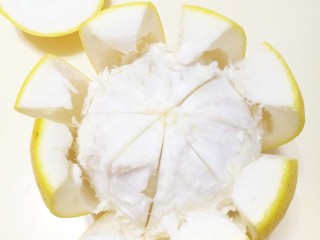 2、超养人的自制蜂蜜柚子茶,柚子切开，削下柚子皮（记得把白瓤去的干净，不然容易很苦）。