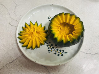 4、糯米南瓜盅,贝贝瓜清洗干净，用雕花刀将贝贝瓜切开，掏出瓜瓤和瓜籽