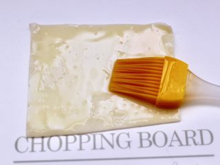 6、馄饨皮香蕉派,取一张馄饨皮，刷满花生油，再放一张馄饨皮刷满花生油。