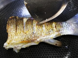 8、红烧草鱼,铲子翻面，文火煎至另一面金黄。