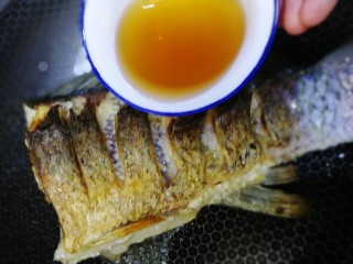 10、红烧草鱼,倒入料酒。