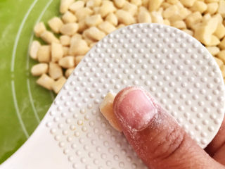 21、炒猫耳朵,取一个小面块，放入饭勺上面，用大拇指向上推撵