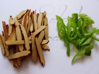 3、凉拌紫甘蓝香干,香干也用刀切成薄片，青尖椒用刀切成丝备用。