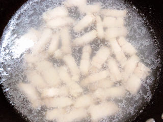 6、红烧土豆,锅中烧开水,放入五花肉条,煮去血水。