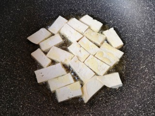 6、蘑菇炖豆腐,炒锅内倒多一些食用油烧热，码入老豆腐。