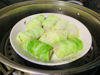 16、白菜包肉,蒸锅先将水烧开,放入白菜包肉,大火蒸10分钟