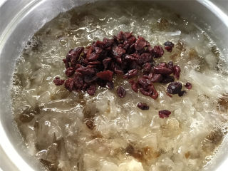 7、蔓越莓桃胶银耳羹,等冰糖融化后加入蔓越莓干，即可熄火。