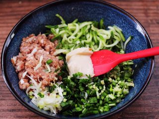 6、双色西葫芦韭菜生煎包,搅拌好的肉馅里，加入纳干水分的西葫芦，切碎的韭菜和葱姜碎，再加入猪油。