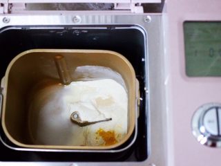 9、双色西葫芦韭菜生煎包,同样的方法，把称重的面粉和南瓜粉加入面包机里，再放入1.5克酵母和85克清水，启动和面模式开始和面。